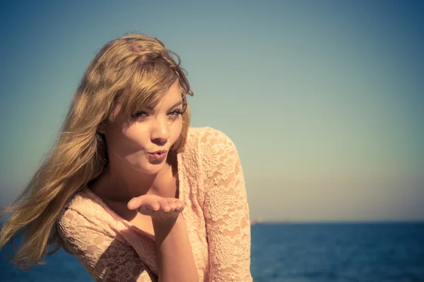 Mooie blonde meisje kus buiten waait door zee — Stockfoto