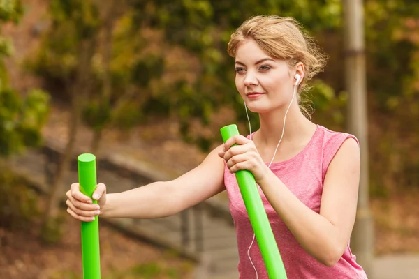 Mujer activa haciendo ejercicio sobre un entrenador elíptico . — Foto de Stock