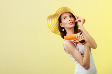 Yaz şapkalı kadın güneş gözlüğü güneş losyonu tutar.