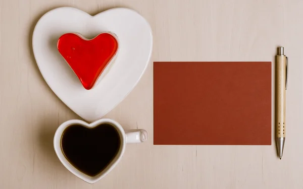 Pastel de taza de café en forma de corazón y papel en blanco —  Fotos de Stock