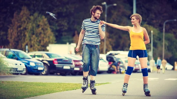 Jovem casal em patins andando ao ar livre — Fotografia de Stock