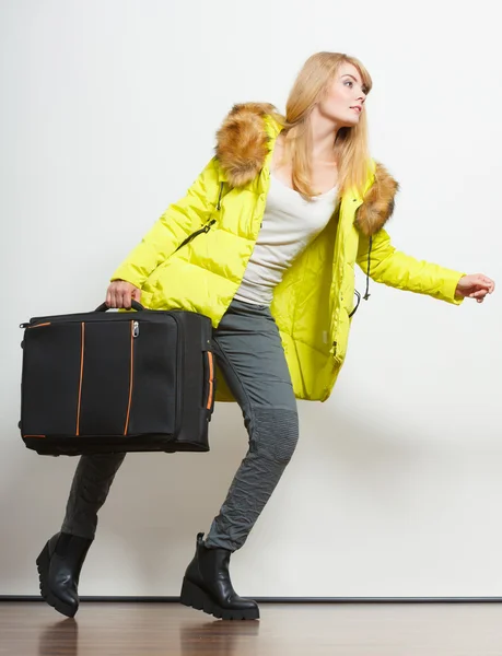 Молодая женщина в теплой куртке с чемоданом . — стоковое фото