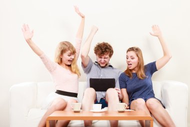 Evde tablet ile başarılı mutlu arkadaşlar.