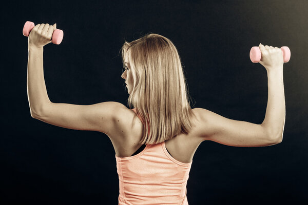Fitness sporty girl lifting weights back view