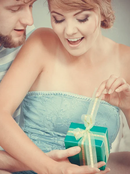 Egy fiatal férfi ajándékdobozt ad a nőnek. — Stock Fotó