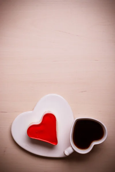 Heart shaped coffee cup and cake on wood surface — Stock Photo, Image