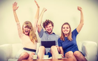 Evde tablet ile başarılı mutlu arkadaşlar.