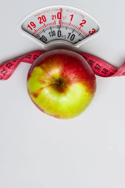 Apple with measuring tape on weight scale. Dieting — Stock Photo, Image