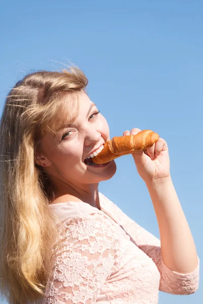 Jeune femme mangeant croissant — Photo