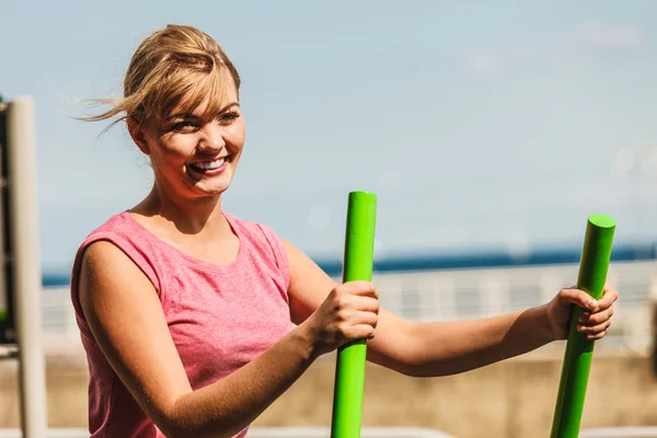 Mujer activa haciendo ejercicio sobre un entrenador elíptico . — Foto de Stock