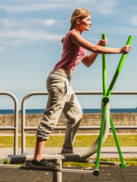 Femme active faisant de l'exercice sur un entraîneur elliptique . — Photo