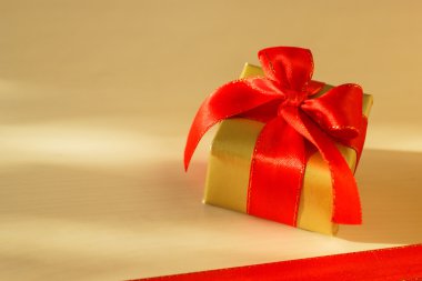 Küçük altın kutu hediye ile kırmızı yay bağlı