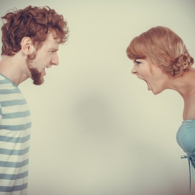 Öfkeli kadın ve erkek birbirlerine bağırıyorlar.