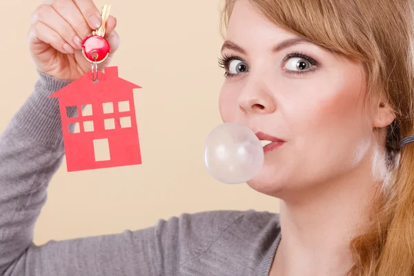 Funny woman holds house keys eat chewing gum — Stock Photo, Image