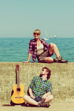 Genç adam onun kız arkadaşı deniz kenarında gitar çalmak