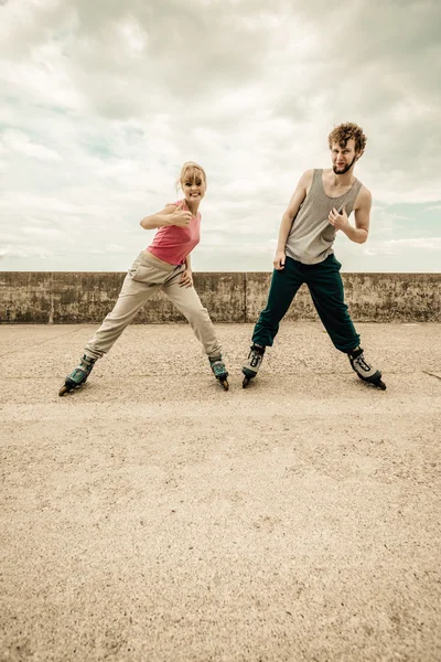 Zwei Personen üben Stretching im Freien auf Rollerblades. — Stockfoto