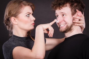 Kadın adamın yüzüne karşı krem uygulamak.