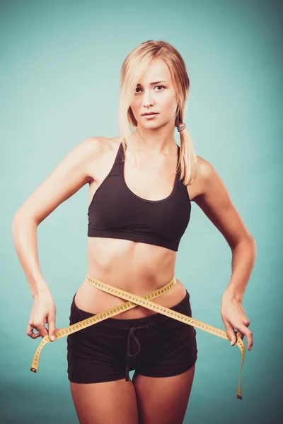Fitness girl measuring her waistline — Stock Photo, Image