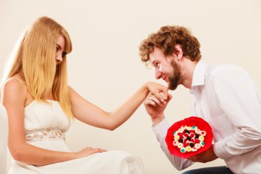 Kadın şeker demet çiçek veren adam. Mutlu çift