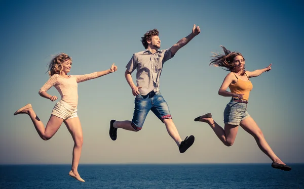 Unbekümmerte Freunde beim Sprung aufs Meer. — Stockfoto