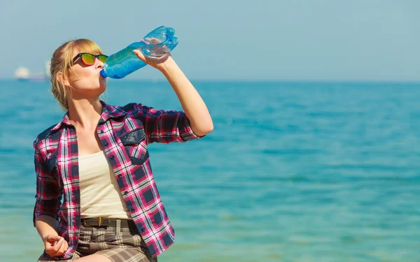 Jonge vrouw drinken van water buiten — Stockfoto