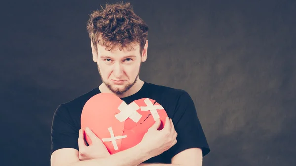 Sad man with glued heart by plaster. — Stock Photo, Image