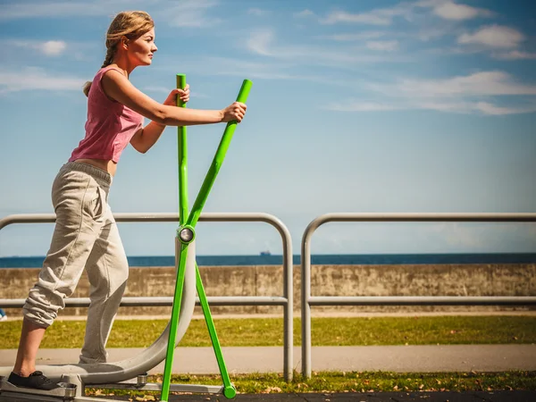 Mulher ativa exercitando-se no treinador elíptico . — Fotografia de Stock