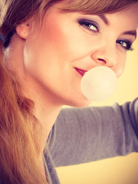 Chica rubia masticando chicle haciendo globo . — Foto de Stock