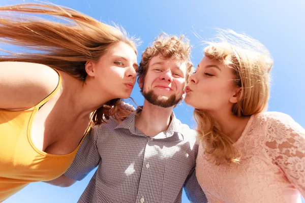 Due ragazze baciare un ragazzo divertirsi all'aperto — Foto Stock