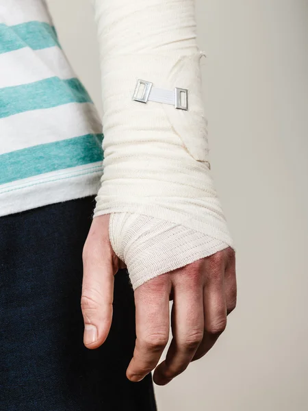 Del kropp man med bandagerade hand. — Stockfoto