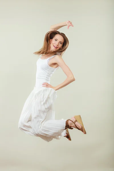 Женщина в белом платье прыгает летом — стоковое фото