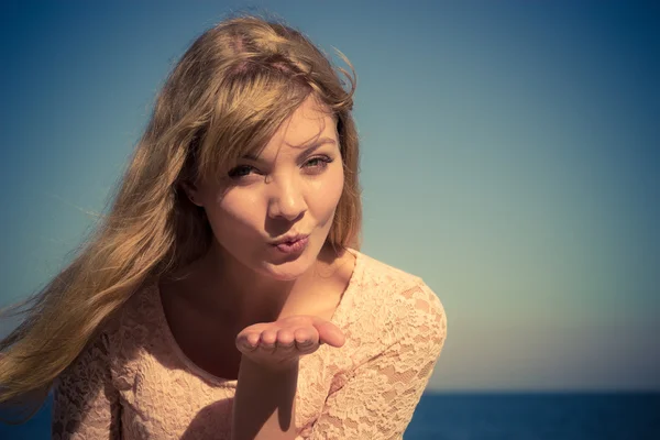 Lovely blonde girl blowing kiss outdoor by seaside — Stock Photo, Image