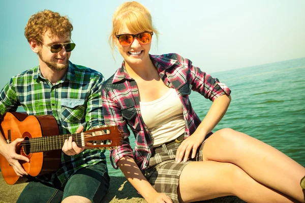 Joven hipster tocando la guitarra para mujer . — Foto de Stock