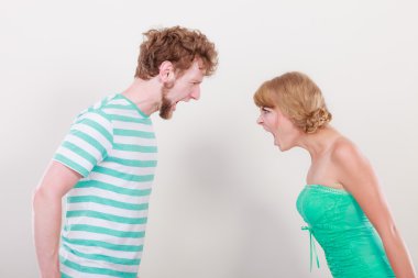 Öfkeli kadın ve erkek birbirlerine bağırıyorlar.