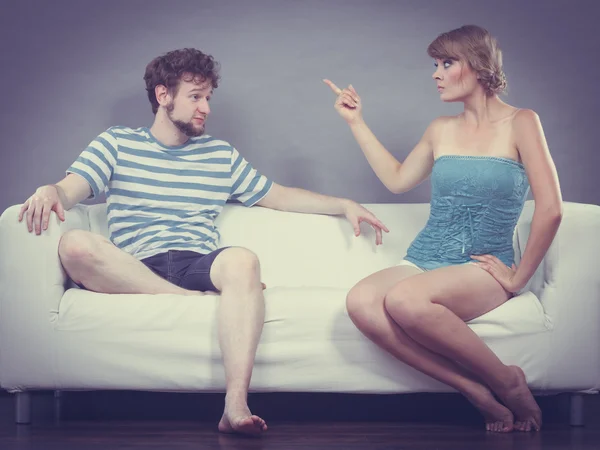 Чоловік і жінка мають суперечку, сидячи на дивані вдома — стокове фото