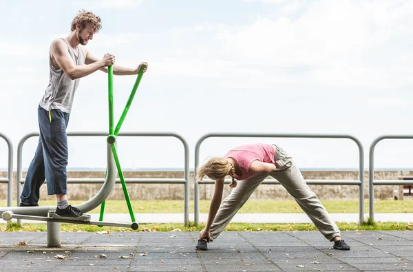 Hombre haciendo ejercicio en elíptica entrenador y mujer . — Foto de Stock