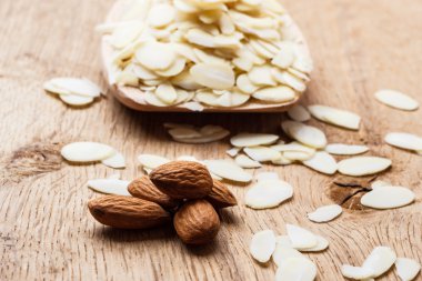 dilimlenmiş ve tüm çiğ badem ahşap yüzey üzerinde