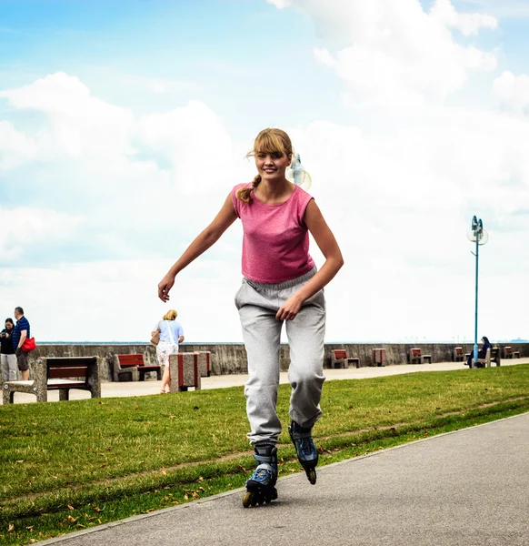 Junge Frauen turnen draußen auf Rollerblades. — Stockfoto