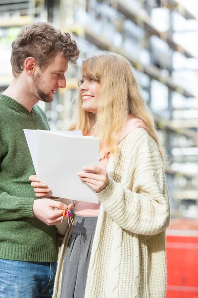 Par med blueprint projektet nycklar på byggarbetsplats — Stockfoto