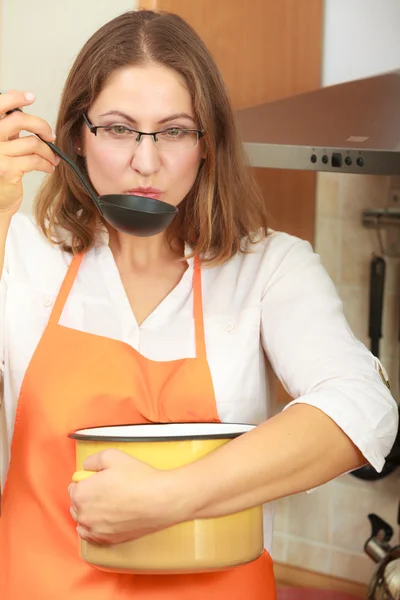 Mulher com concha e panela na cozinha — Fotografia de Stock