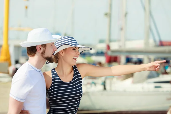 Туристическая пара в марине против яхт в порту — стоковое фото