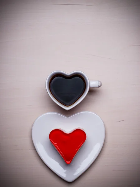 Copa de café en forma de corazón y pastel en la superficie de madera —  Fotos de Stock