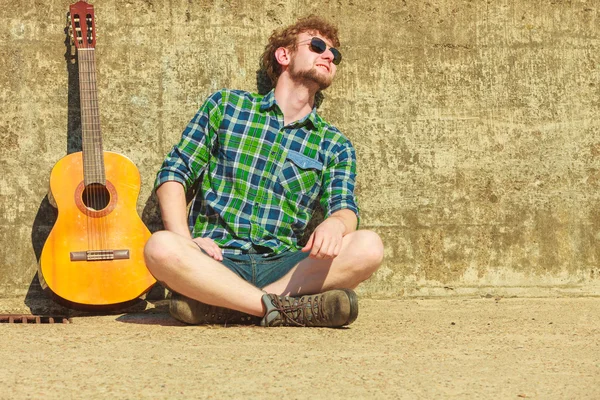 Joven barbudo hipster hombre con guitarra al aire libre — Foto de Stock