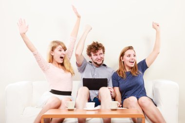 Evde tablet ile başarılı mutlu arkadaşlar.