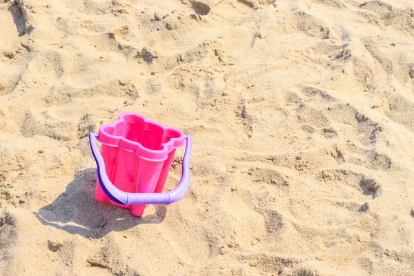 Zabawki małe wiaderko piasku na plaży latem. — Zdjęcie stockowe