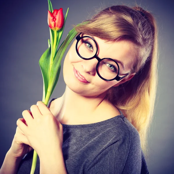 Нерді дівчина нюхає квітку . — стокове фото