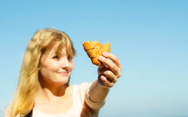 Молодая женщина ест круассаны на открытом воздухе . — стоковое фото