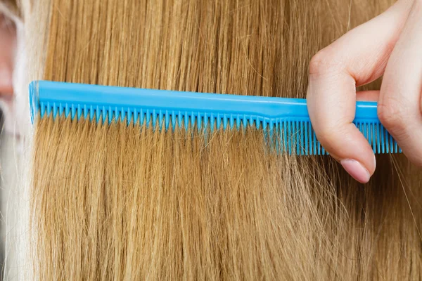 Close up of blue comb in blonde hair. — Stock Photo, Image