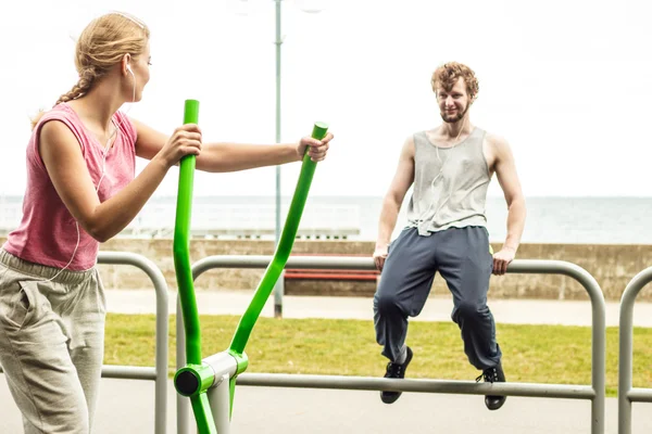 Hombre y mujer haciendo ejercicio sobre un entrenador elíptico . — Foto de Stock