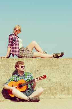 Genç adam onun kız arkadaşı deniz kenarında gitar çalmak